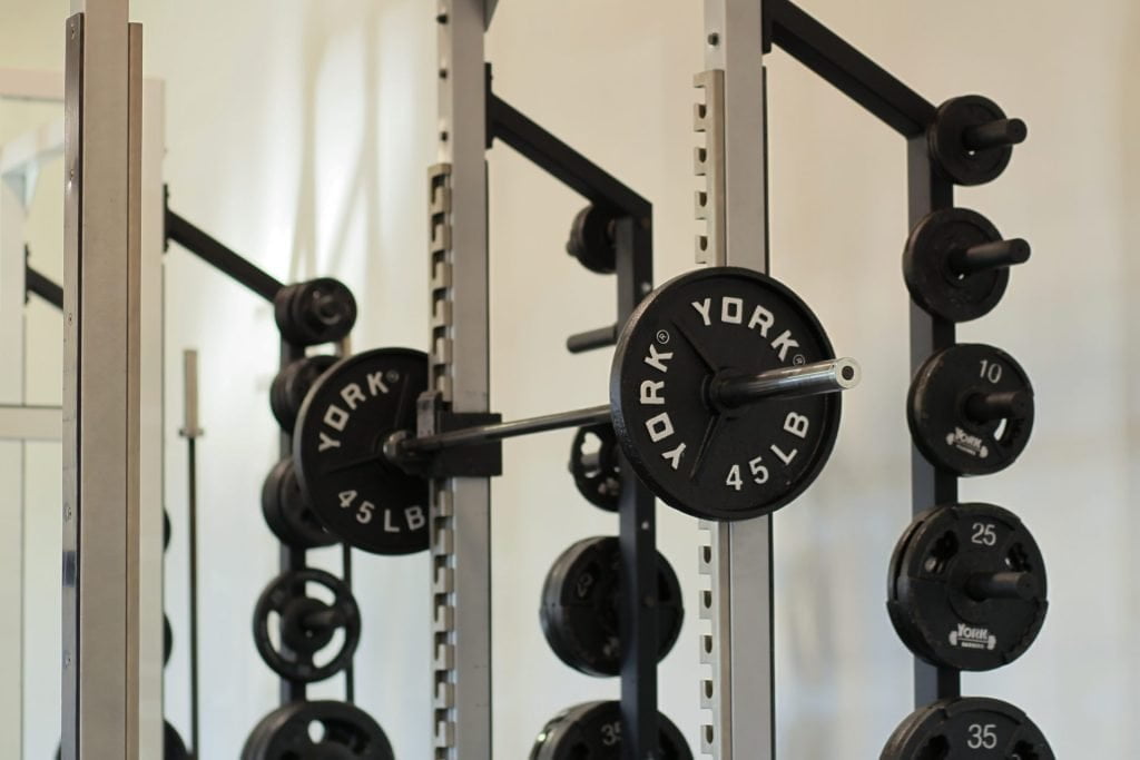 York plates and barbell on a rack.
